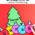 Green christmas tree with the name "sarah" on it with multicolored paper ornaments with the letters of the name on them