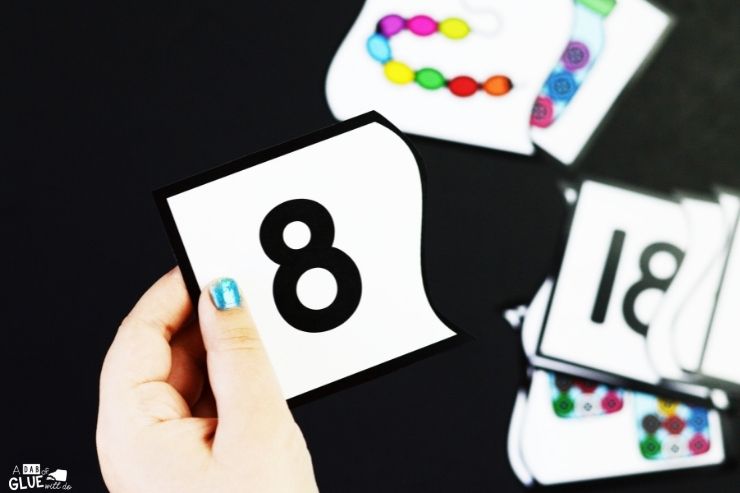 child holding puzzle piece with the number 8. learning number sense