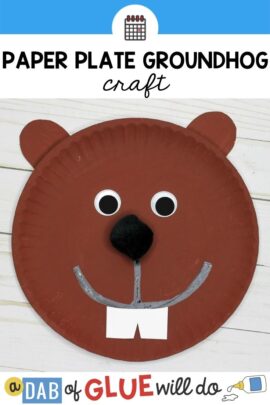 Brown paper plate with a groundhog face glued on.