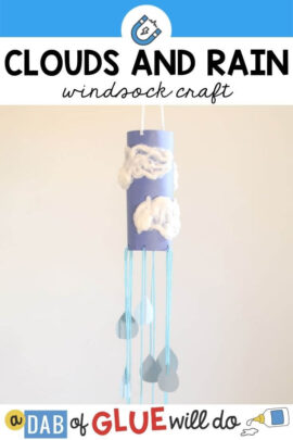 A homemade windsock made with blue construction paper, cotton ball clouds, and yarn hanging down.