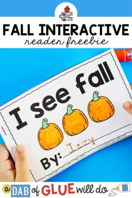 A child holding an emergent reader titled "I see Fall" with three colored in orange pumpkins.