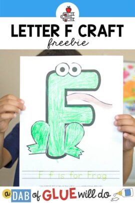 A child holding up a F is for frog craft