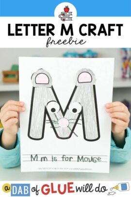 A child holding a M is for Mouse craft