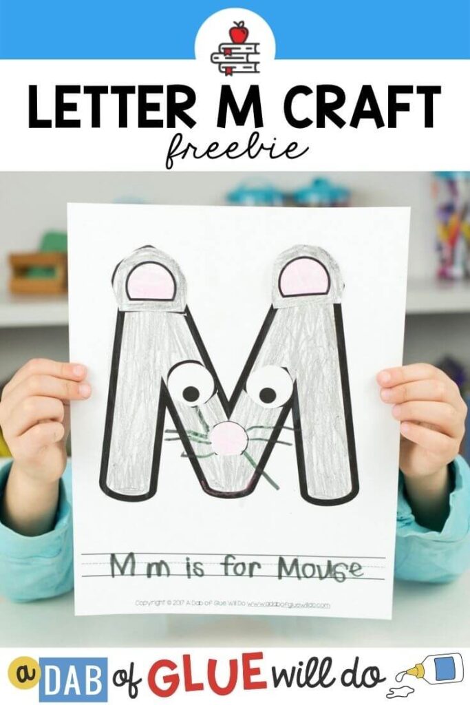 A child holding a M is for Mouse craft