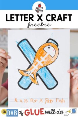 A child holding up an X is for X-ray fish craft