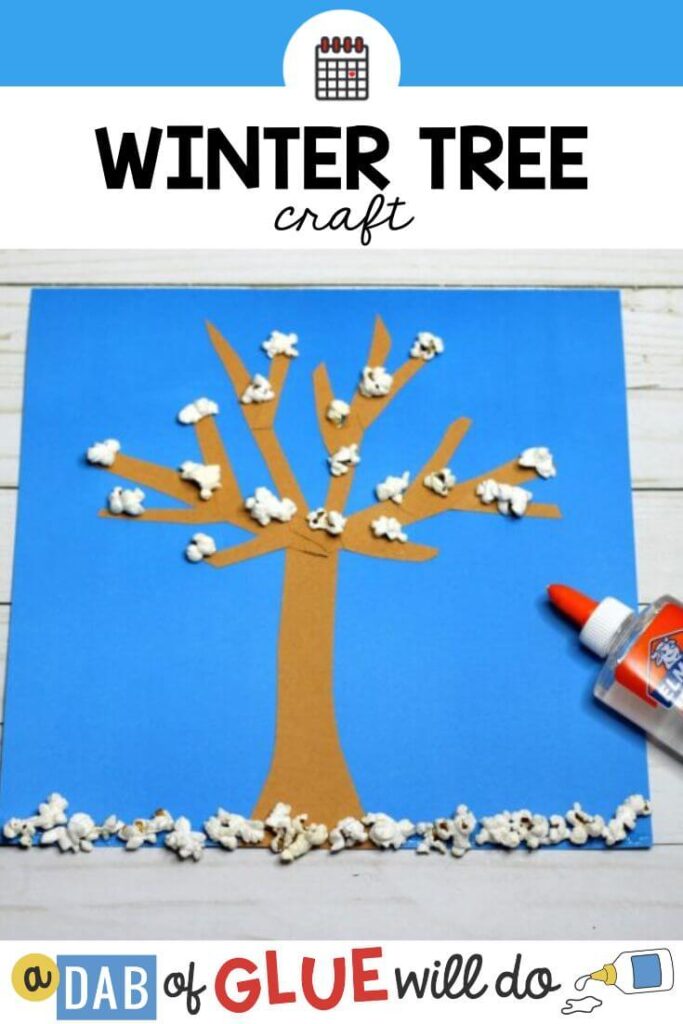 A winter tree craft on blue paper made with popcorn
